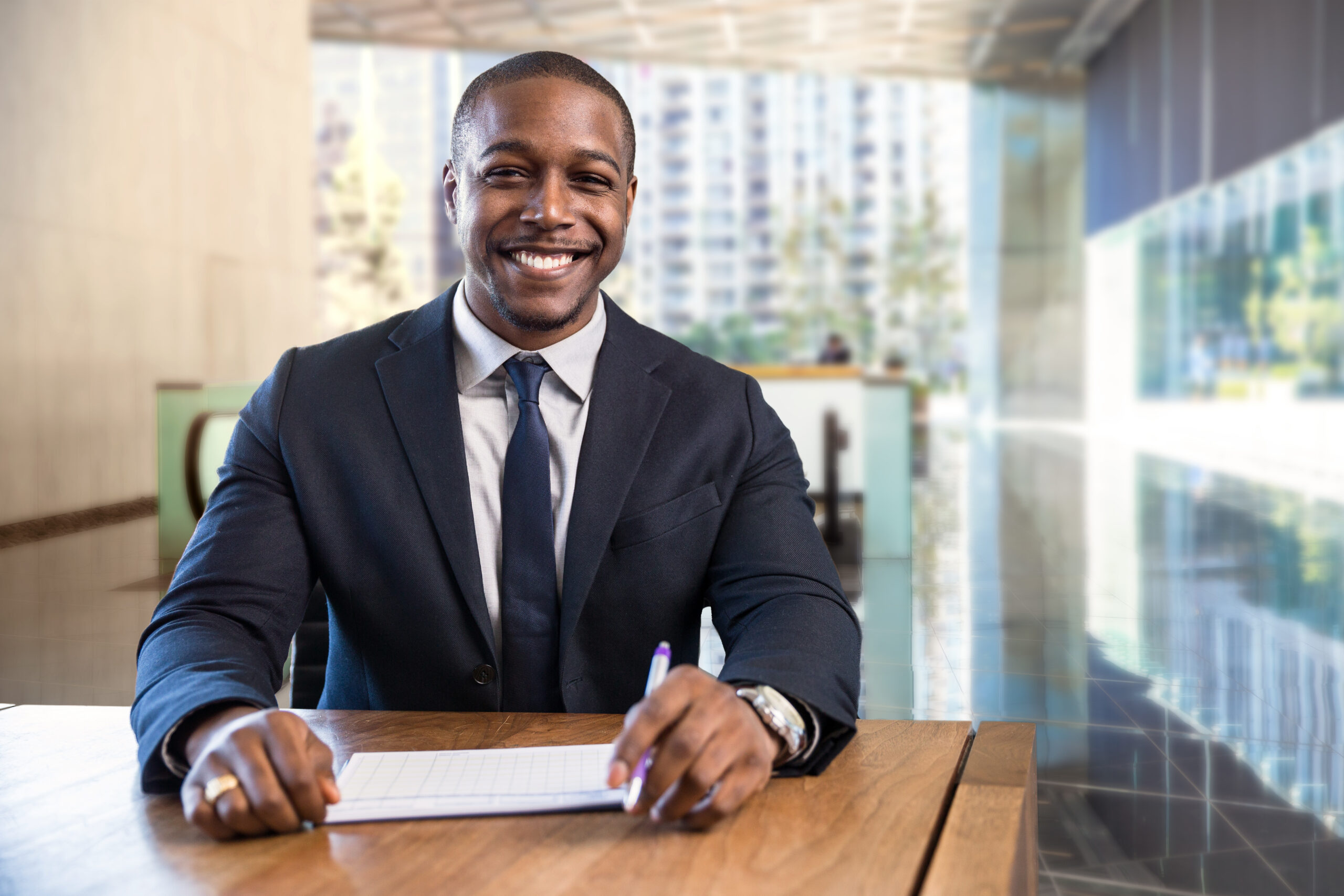 Charming warm friendly smile from stylish financial sales manager sitting at desk with paperwork