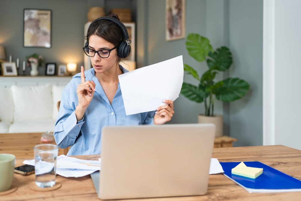 Executive personal assistant reviewing a merged business and personal calendar at a home office desk